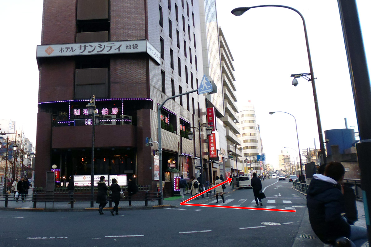 横断道先の茶色の建物「ホテルサンシティ」